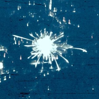 Shattered glass fragments on dark surface.