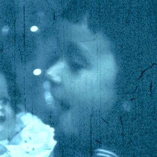 Blurred reflection of woman holding child indoors.