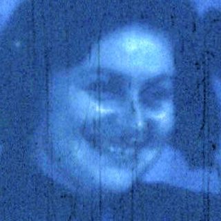 Blurred indoor portrait of person smiling.