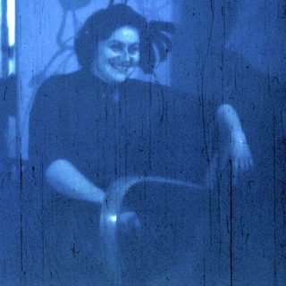 Blurred indoor portrait of person smiling.