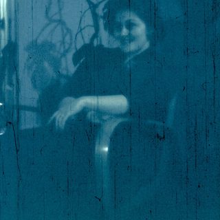 Silhouette of two people through a window.
