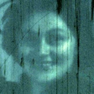 Blurred reflection of person sitting on window ledge.