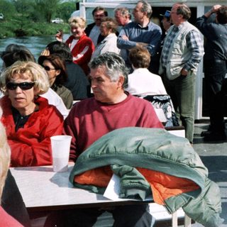 Boat party with people dining outdoors.