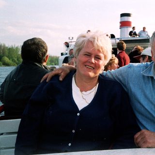 Happy couple posing on a boat by water.