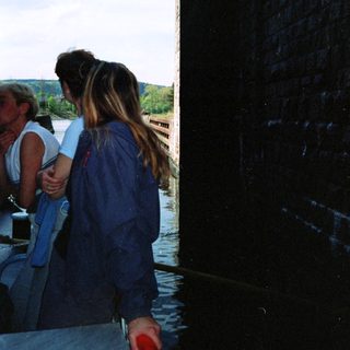 People standing near water, framed by doorway.