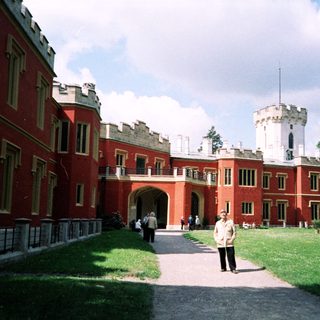 Historic red-brick castle with central tower.