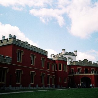 Historic red castle-like building with towers.