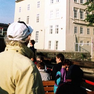 Large historic building with people gathered outside.