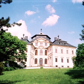 Elegant classical-style palace surrounded by greenery.