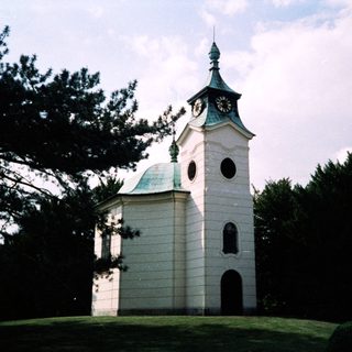 White church tower with clock and dome.