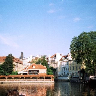 Scenic European riverside town with historic buildings.