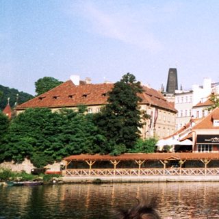 Scenic European riverside town with historic buildings.