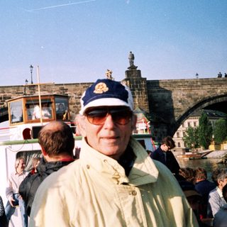 Man on bridge near historic boat tour.