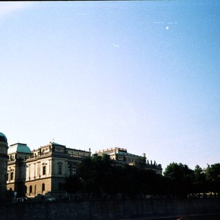 Historic European buildings by riverbank.
