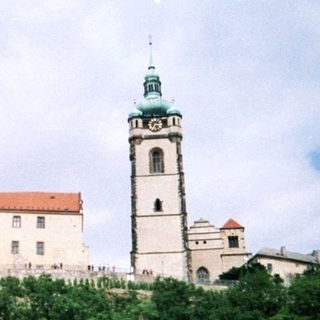 Historic castle with tall tower atop hill.