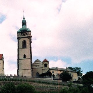Historic castle complex with tall bell tower.