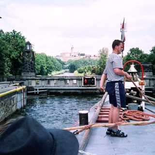 Lock operator ringing bell at canal waterway.