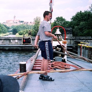 Lock operator ringing bell at canal waterway.