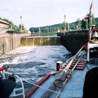 Lock gate with boat passing through water level transition.