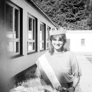 Young woman wearing graduation sash and cap.