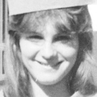 Young woman wearing graduation sash and cap.