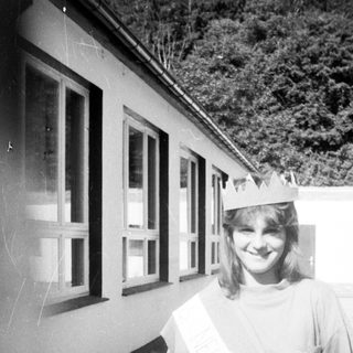 Young woman wearing graduation sash and cap.