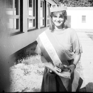 Young woman wearing graduation sash and cap.