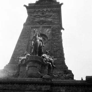 Monumental equestrian statue atop stone tower.