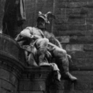 Monumental equestrian statue atop stone tower.