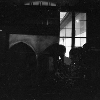 Silhouette of person standing near window at night.