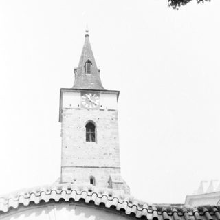 Historic church tower with arched bell window.