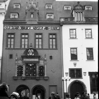 Historic European building with ornate facade and people walking outside.