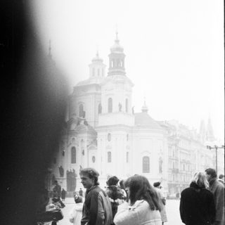Baroque church with people in public square.