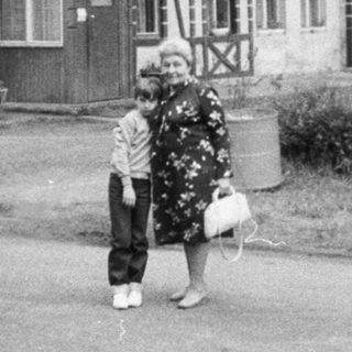 Vintage photo of café "Kavarna" with two people outside.