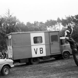 Person jumping over moving truck labeled VB.