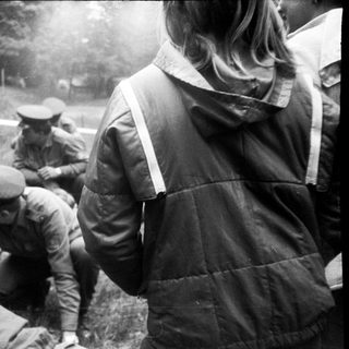 Soldiers assisting a fallen comrade outdoors.