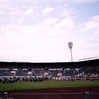 Large stadium with crowd and organized fan displays.