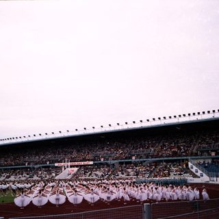 Large stadium crowd watching synchronized dance performance.
