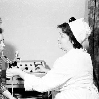 Nurse performing dental examination on patient.