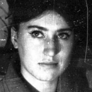 A person in a dark, cracked-glass interior.
