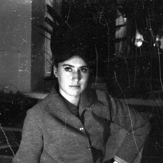 A person in a dark, cracked-glass interior.
