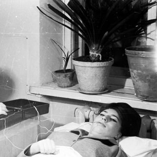 Medical professional performing electroconvulsive therapy on patient.