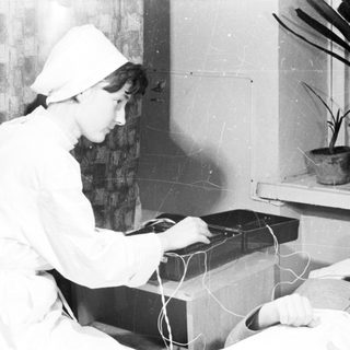 Medical professional performing electroconvulsive therapy on patient.