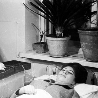 Medical professional performing electroconvulsive therapy on patient.