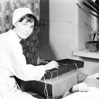 Medical professional performing electroconvulsive therapy on patient.