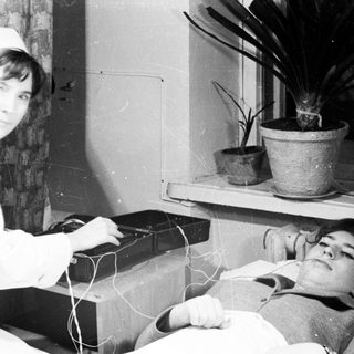 Medical professional performing electroconvulsive therapy on patient.