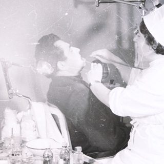 Medical procedure using oxygen therapy in 1950s-style clinic.