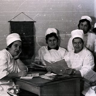 Nurses and doctor in 1950s-60s medical facility uniforms.