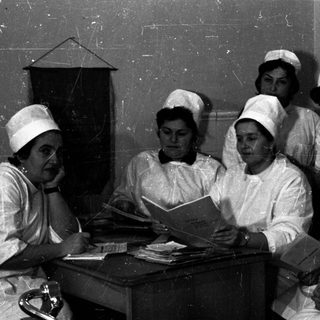 Nursing students and instructor studying together indoors.
