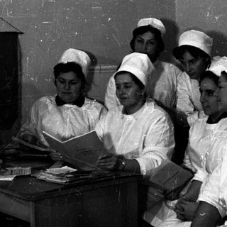 Nursing students and instructor studying together indoors.